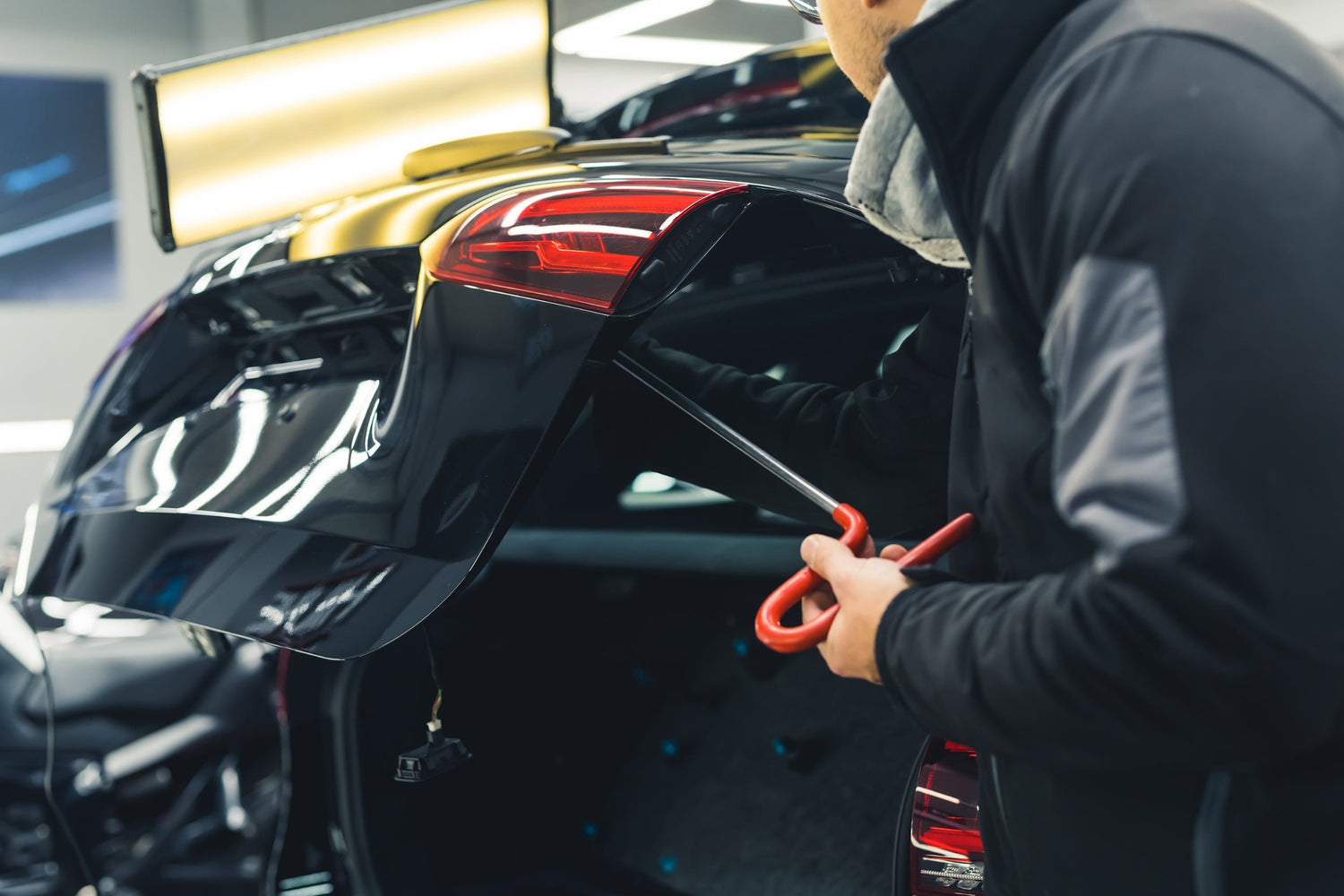 Technician using PDR hand tool to fix a car dent at Apex Precision Repair in Denver